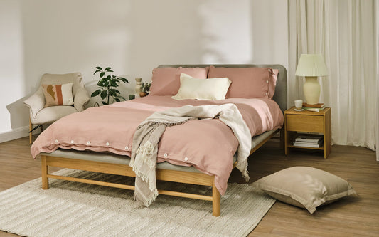 A beautiful made bed with a set of Koala sheets, duvet cover, throw and pillow.