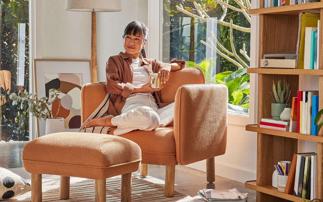 A woman sits on the most comfortable armchair she has sat on in her beautiful sunny living room
