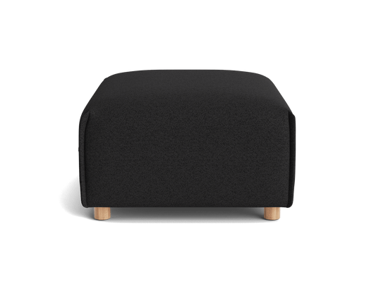 Black ottoman with a square shape and light wooden legs against a plain background.