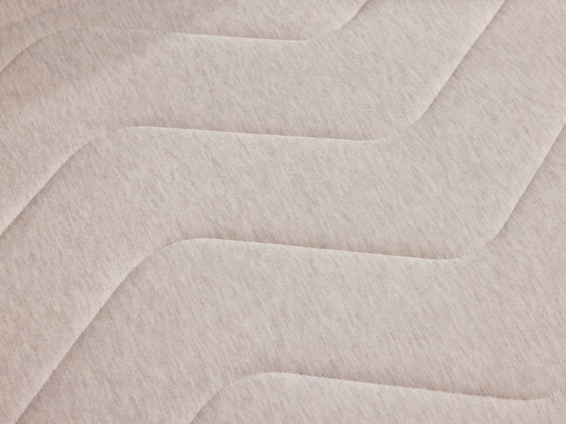 Light grey mattress fabric with a subtle zigzag quilted pattern, showcasing a textured and comfortable surface.