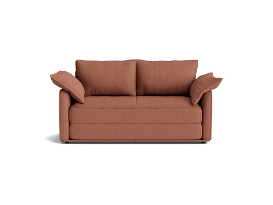 Rust-coloured sofa with two large back cushions and two side cushions. Simple, modern design suitable for living rooms.