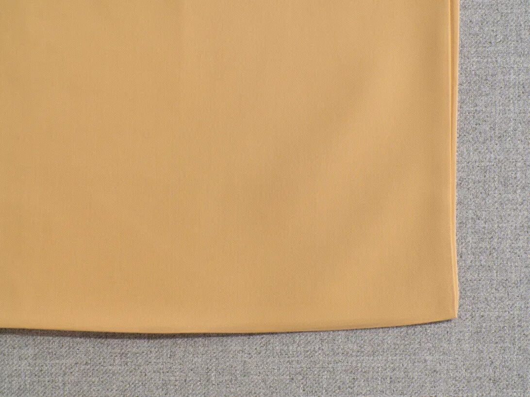 Close-up of a beige fabric corner overlaying light grey textured material, showcasing upholstery fabric contrast.