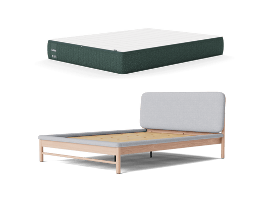 Mattress with a dark grey base and white top, paired with a light wood bed frame featuring a light grey upholstered headboard.