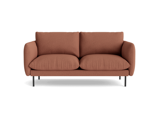Two-seater sofa in terracotta fabric, featuring plush cushions and slim black metal legs.