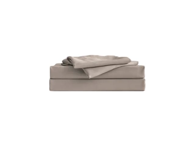 Folded light brown bedding set, neatly stacked with a quilt on top. Perfect for bedroom decor and comfort.