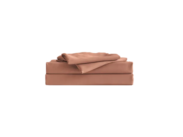 Folded light brown bed sheet set on a white background.