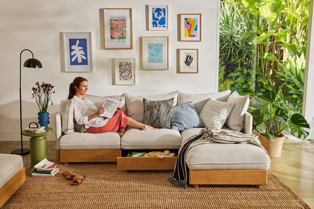 A woman relaxes on a Koala sofa with chaise as she reads a book in a bright and clean lounge room