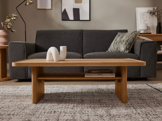 A woman starts decorating her coffee table with a simple vase of flowers