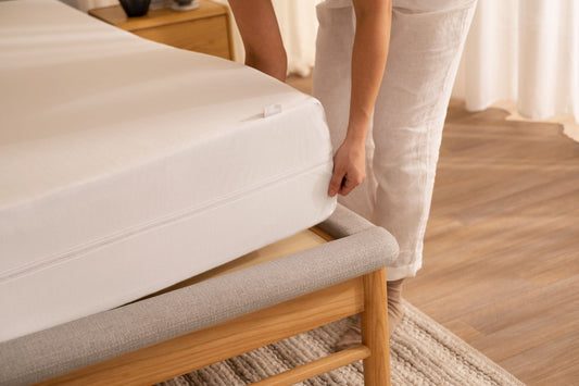 A woman smooths down her mattress protector on her Koala mattress