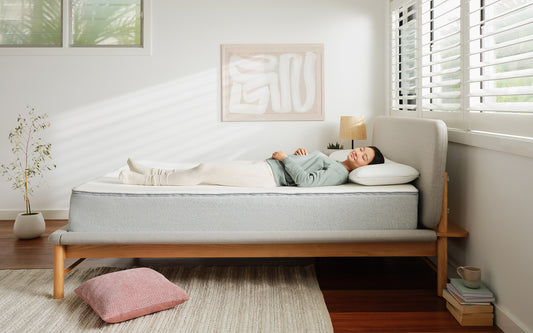 A woman finds her best sleeping position as she relaxes on her back on a Koala mattress
