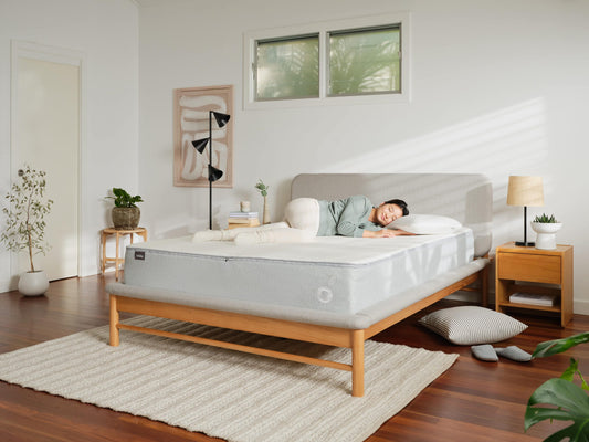 Woman lying on her side in bed, clearly enjoying a sleep in a room that’s at the best temperature for sleep