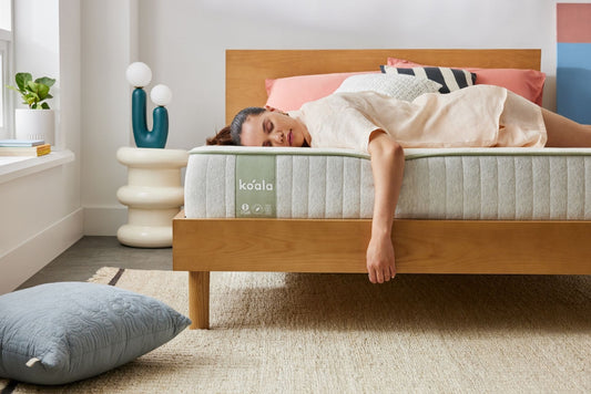 A woman enjoys a champagne sleep on a beer budget thanks to her new Koala SE mattress, after buying a mattress online at Koala