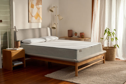 Koala mattress on a Koala bed frame in a roomy bedroom with timber floors, white walls and accessories