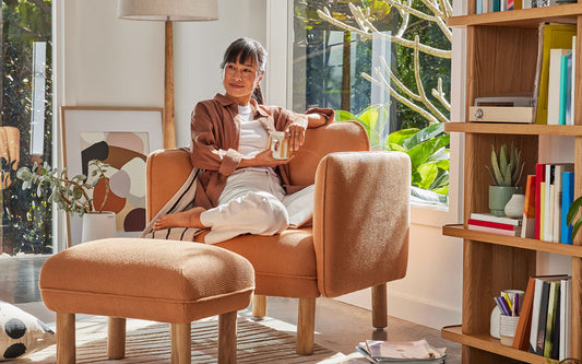 A woman sits on the most comfortable armchair she has sat on in her beautiful sunny living room