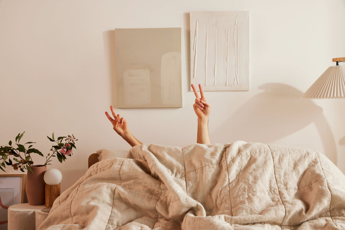 A couple under a cozy Koala duvet share an intimate moment in a beautifully designed, modern bedroom.