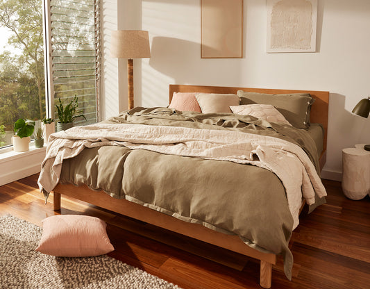 A bedroom with large windows, timber floor and timber frame Koala bed with Koala sheets