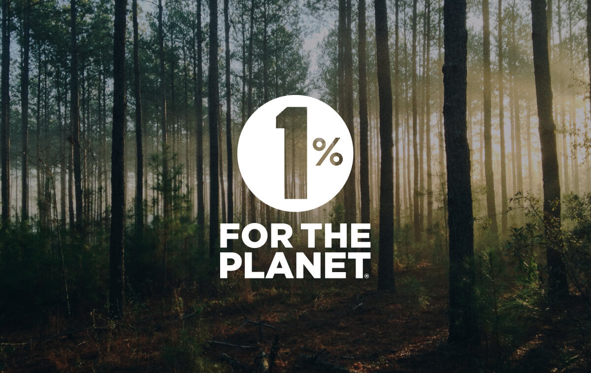 Forest scene at sunrise with tall trees and sunlight filtering through. "1% for the Planet" text in bold white font overlays the image.