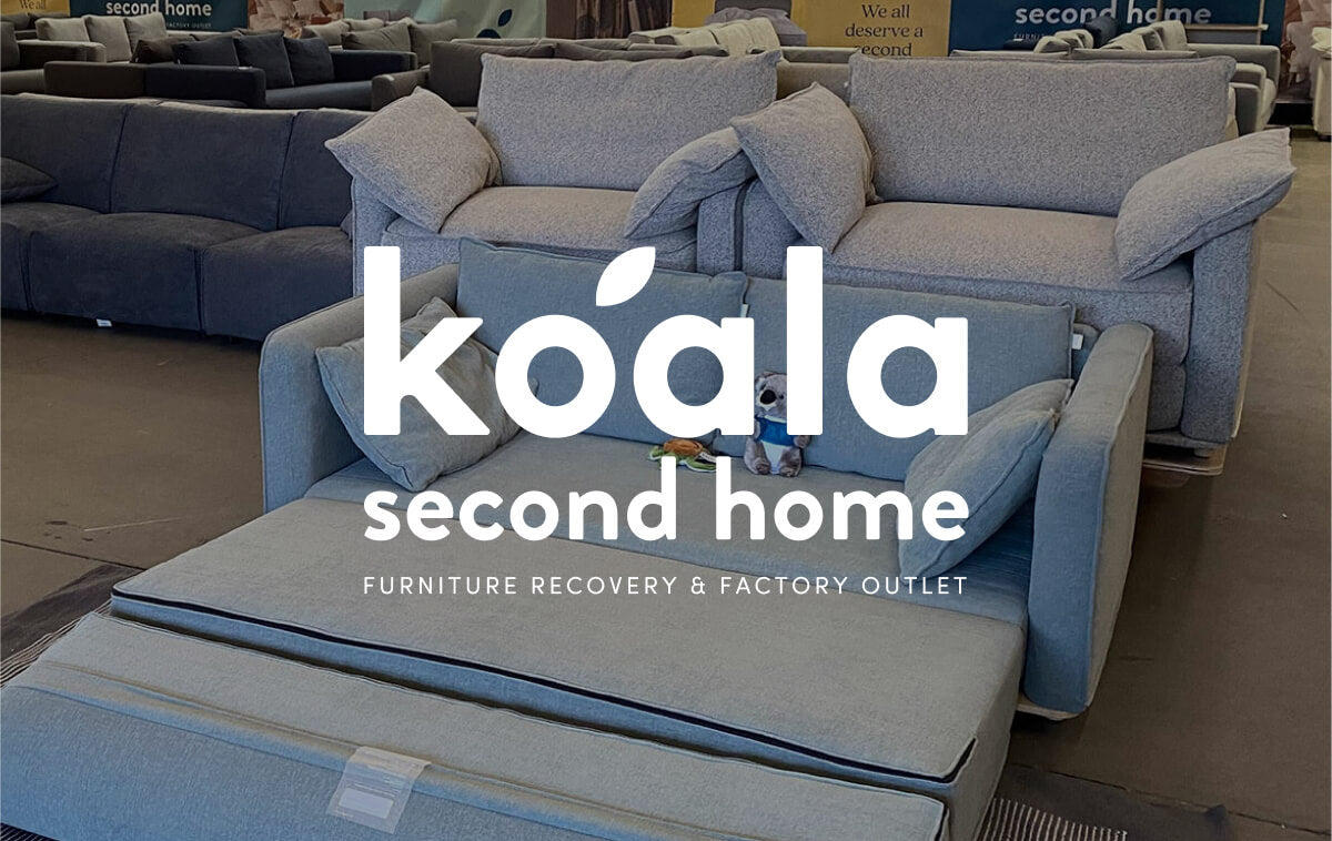 Showroom with assorted couches in light grey and blue hues. Text overlay reads "koala second home, furniture recovery & factory outlet."