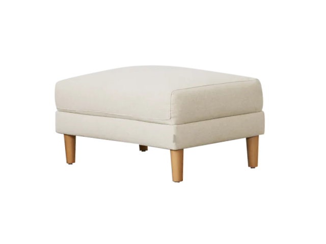 Beige upholstered ottoman with a plush cushion, supported by four light brown wooden legs.