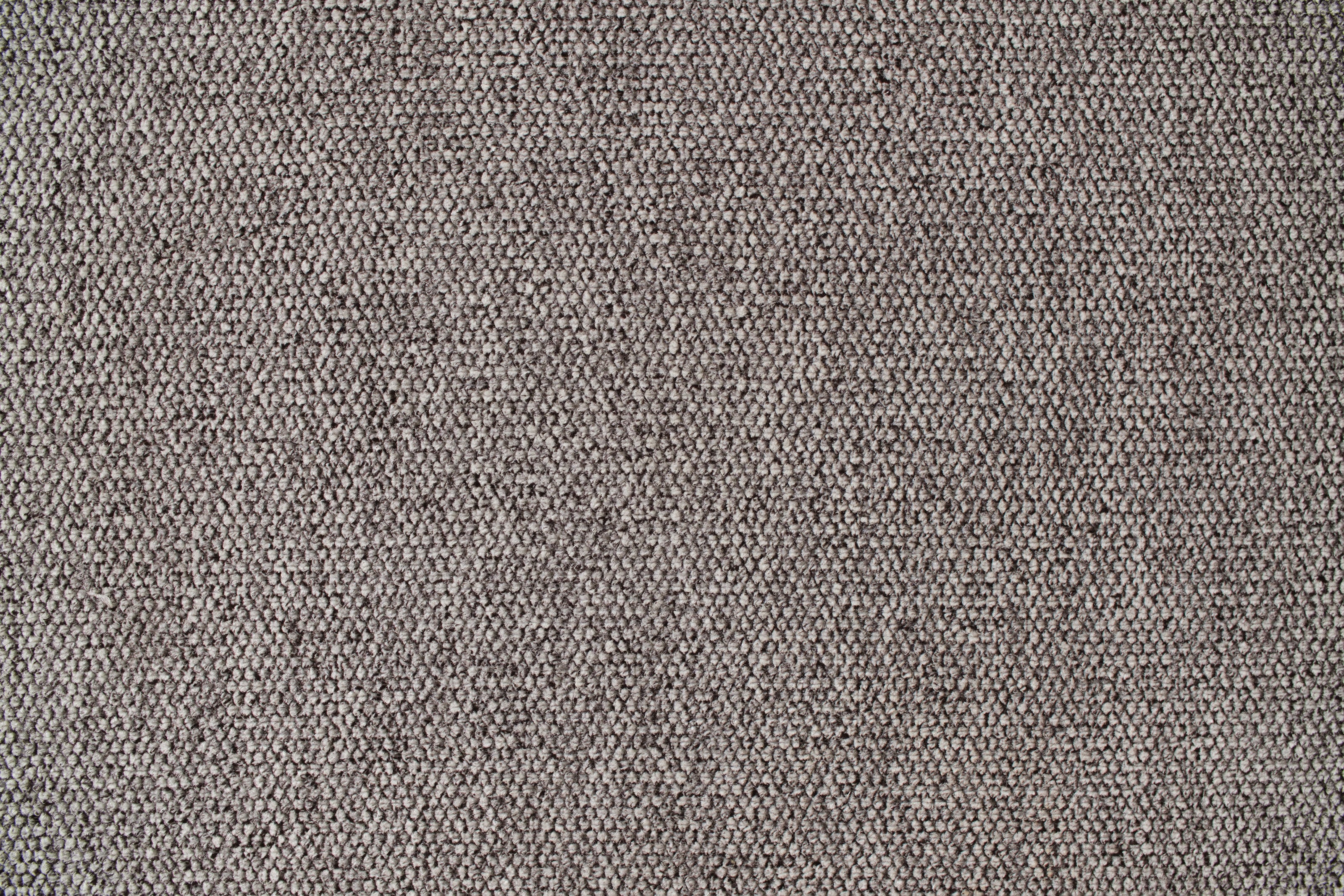 Close-up of textured light grey fabric upholstery, showcasing a woven pattern. Ideal for sofas, chairs, and modern home décor.