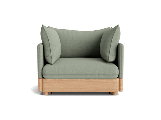 Green cushioned armchair with wooden base, featuring wide armrests and two plush pillows.