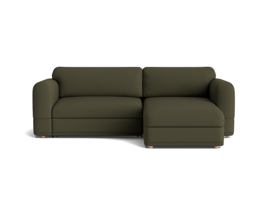 Dark green sectional sofa with rounded arms and a chaise on the right. It has a sleek, modern design with wooden legs.