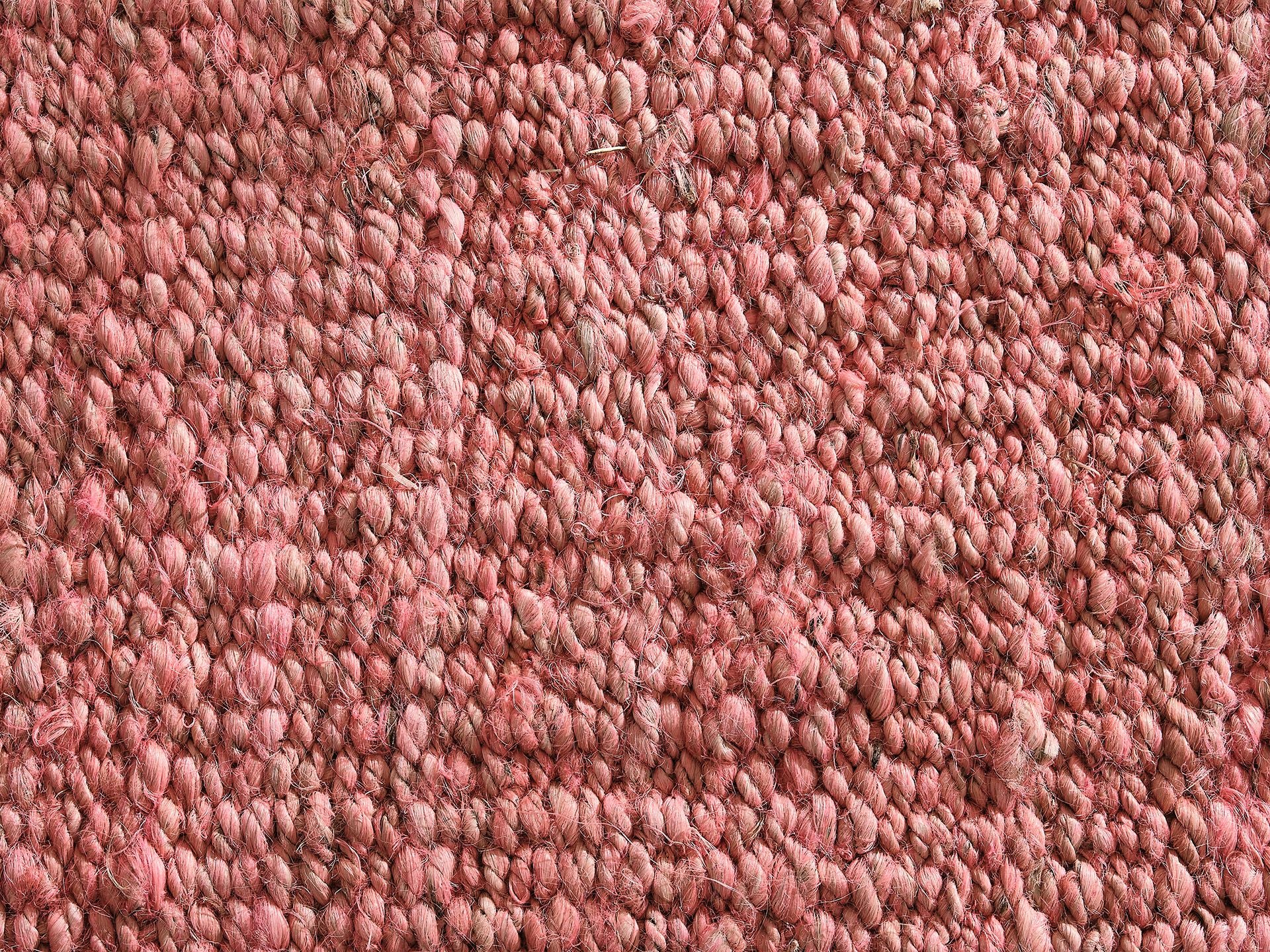 Close-up of a textured, woven fabric in pink, featuring tightly looped fibres. Ideal for upholstery or carpet detailing.