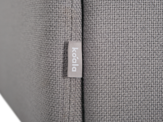 Close-up of a grey textured fabric couch with a small tag labelled "koala".