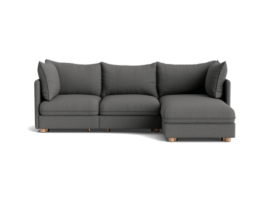 Dark grey L-shaped sectional sofa with plush cushions and wooden legs, viewed from the front.