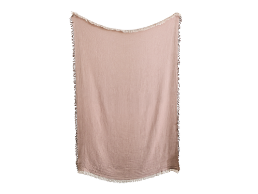 Dusty pink throw blanket with a crinkled texture and white fringe trim, hanging vertically.