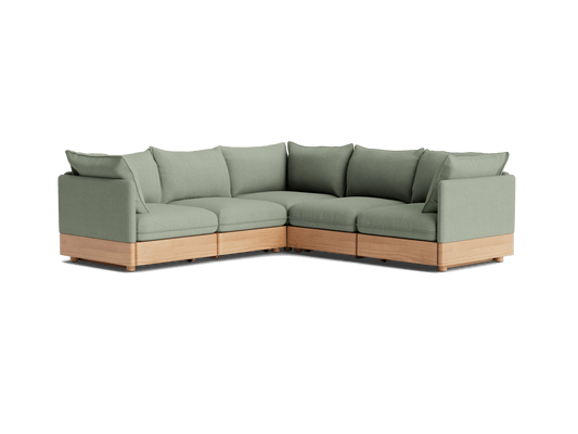 Light green L-shaped sectional sofa with wooden base, featuring plush cushions and a modern design.