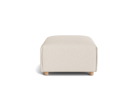 Rectangular beige ottoman with rounded edges and wooden legs viewed from the front on a plain surface