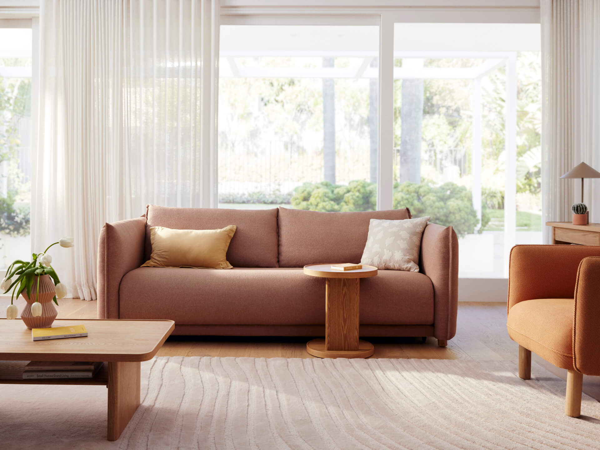 Contemporary living room with a light brown sofa, gold and beige cushions, wooden coffee and side tables, and earthy-toned decor.