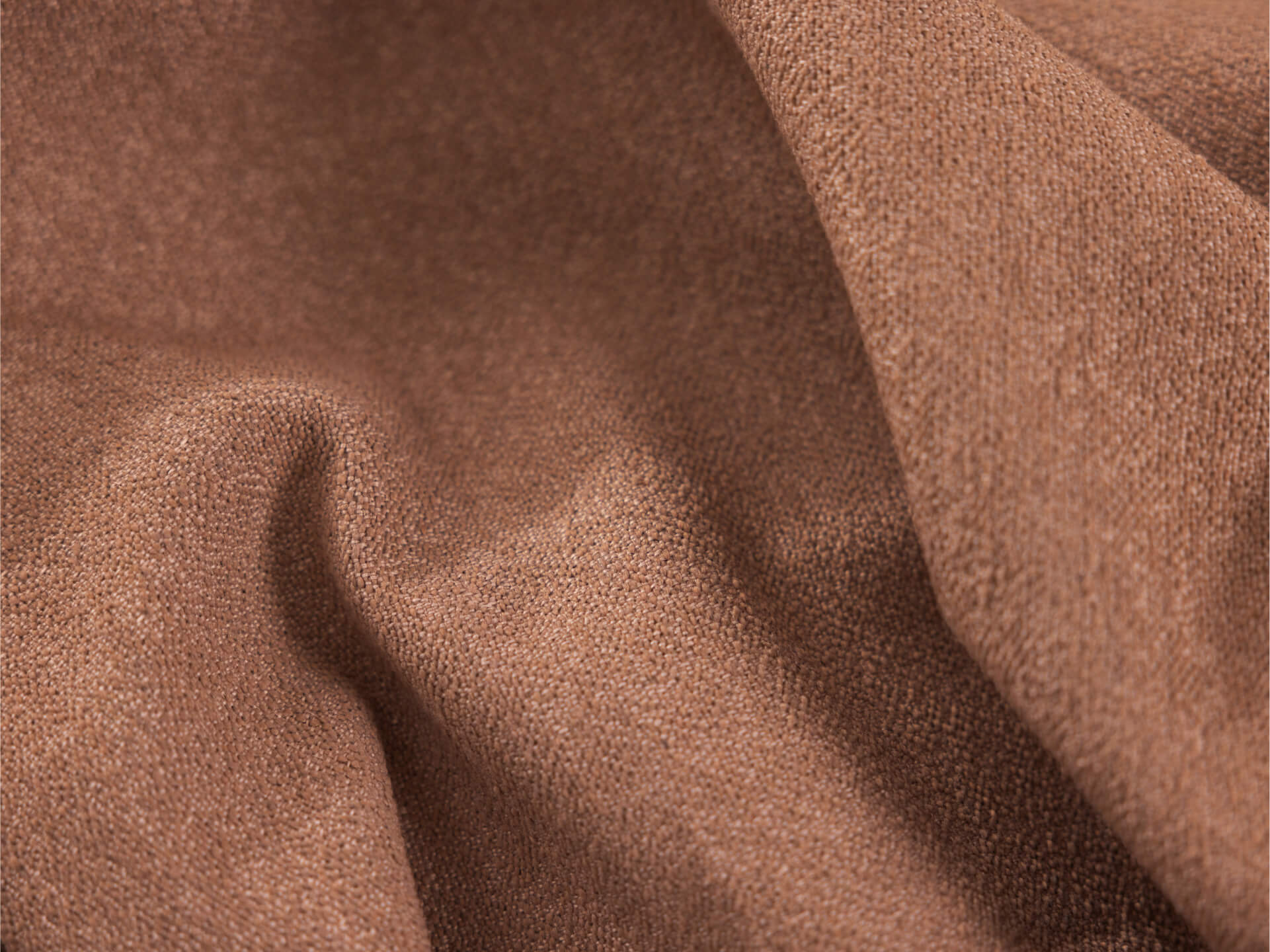 Close-up of brown fabric with a soft, textured surface and gentle folds, ideal for upholstery or home decor projects.