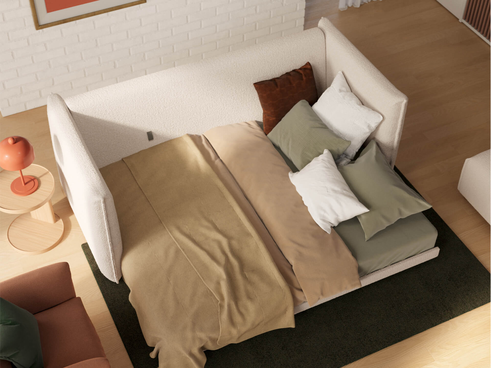 Aerial view of a cream daybed with brown and green bedding, set on a dark rug. A round wooden side table with an orange lamp nearby.