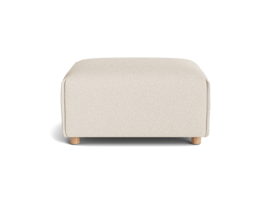 Cream-coloured rectangular ottoman with a textured fabric surface and four light wood legs.