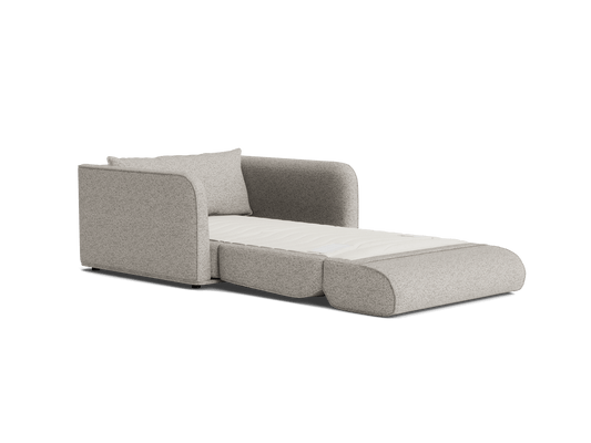 Grey sofa bed with rounded arms, extended into a bed position. Light-coloured mattress, single cushion, modern design. Ideal for small spaces.