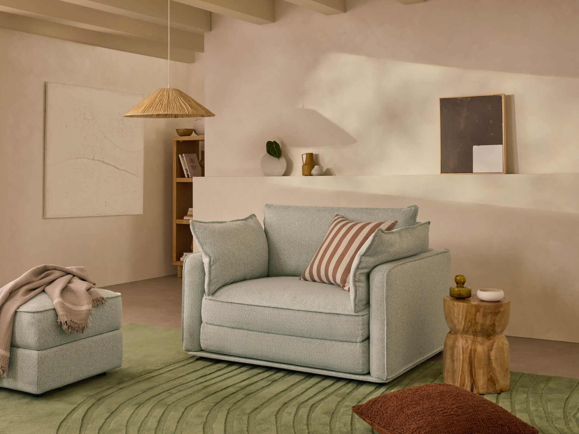 Cosy living room with a light green armchair, matching ottoman, and green rug. Wooden side table, striped cushion, and minimalist decor.