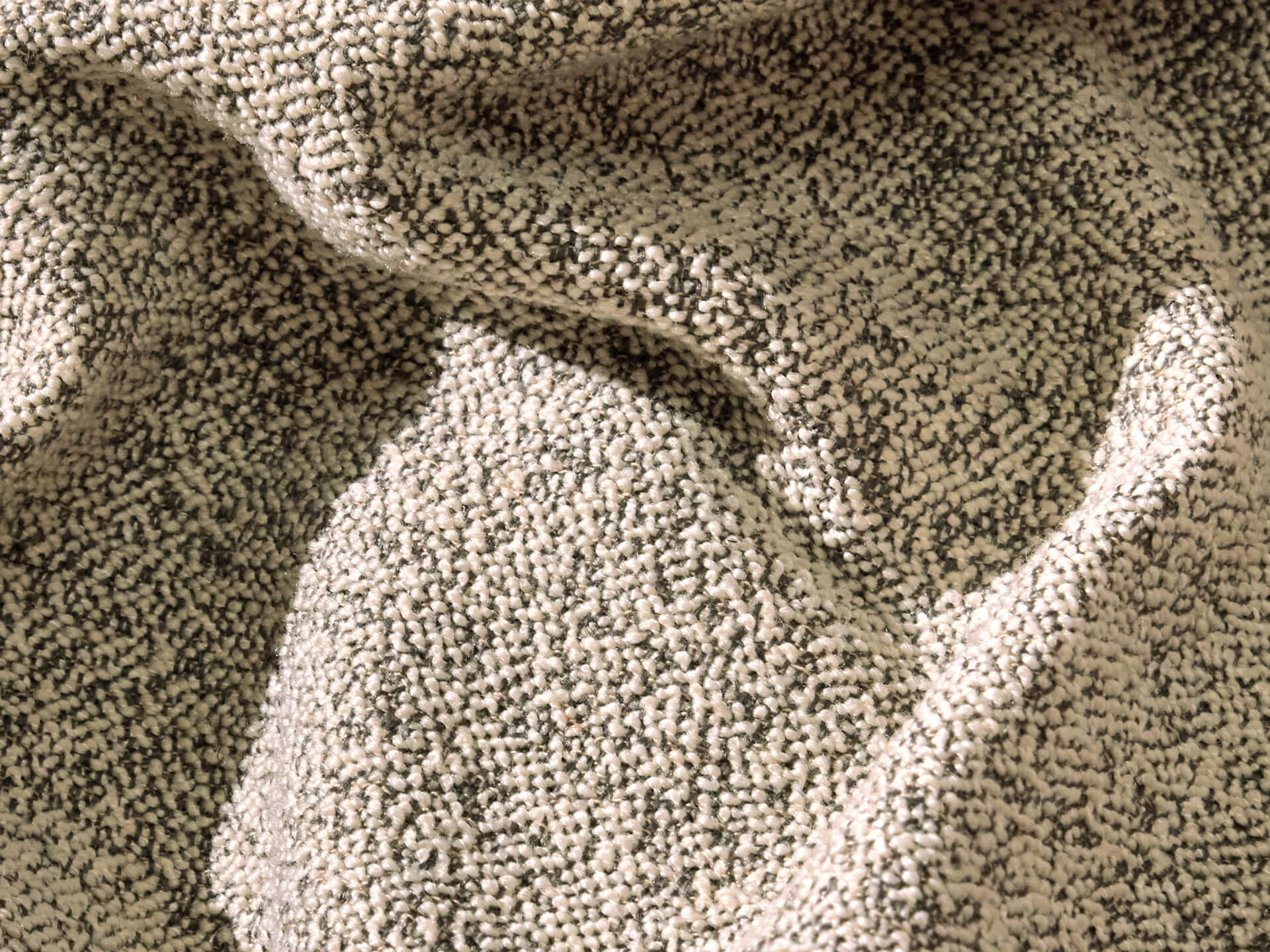 Textured cream and grey fabric with small loops and a tactile, cosy appearance, often used for upholstery or cushions.