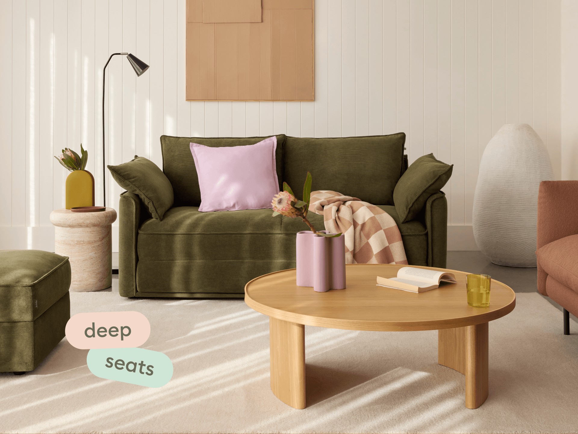 Koala Sofa Bed Queen in olive green corduroy in styled living room with glass coffee table and cushions