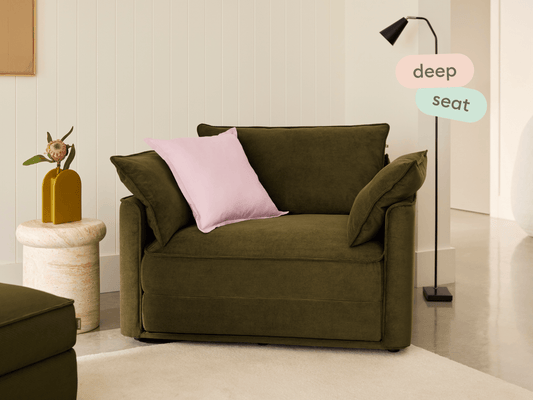 Koala Sofa Bed Single in olive green corduroy in styled living room with glass coffee table and cushions