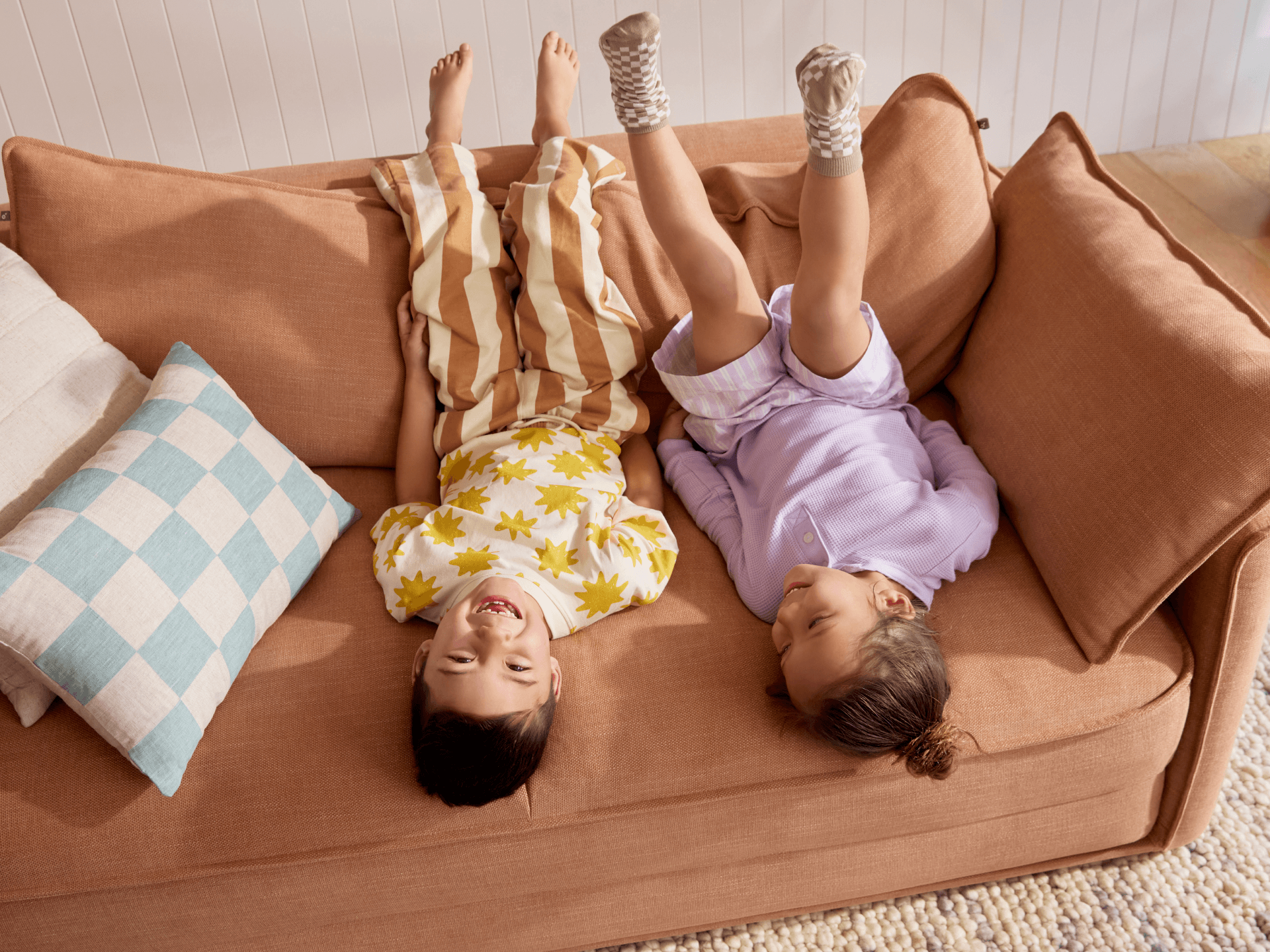 Koala Cushy Sofa Bed in terracotta with person relaxing in lifestyle setting