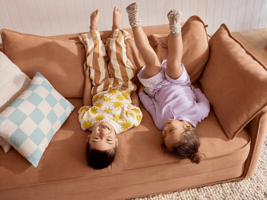 Koala Cushy Sofa Bed in terracotta with person relaxing in lifestyle setting