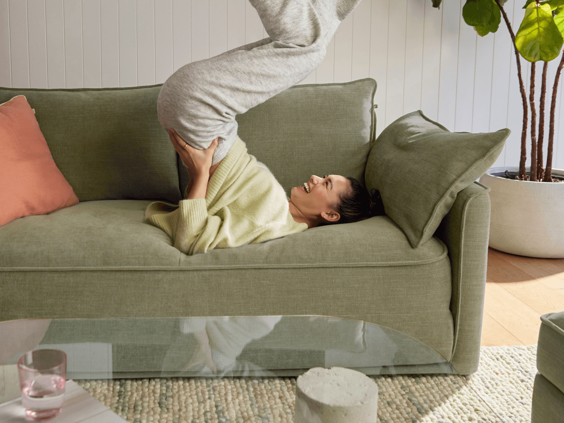 Koala Cushy Sofa Bed in olive green with person relaxing in lifestyle setting