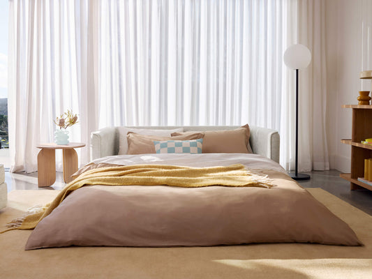 Koala Cushy Sofa Bed in sandstone unfolded into bed mode in styled room