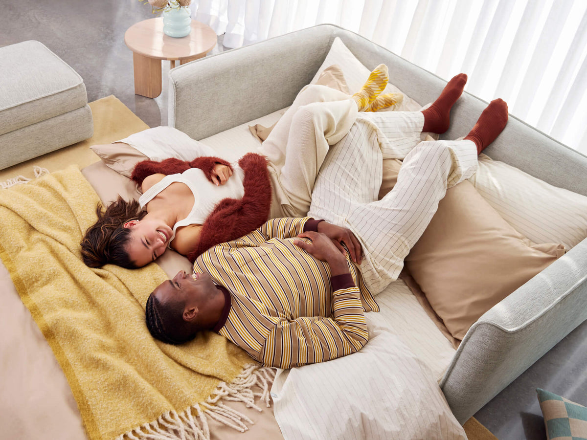 Koala Cushy Sofa Bed in sandstone with people lounging in bed mode