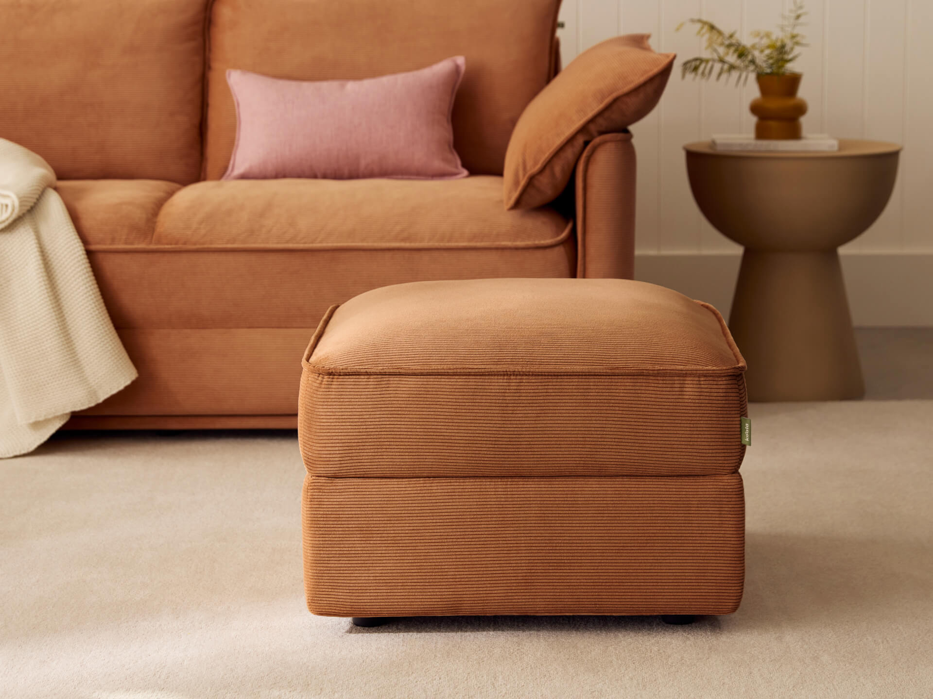 Koala Sofa Bed Ottoman in terracotta corduroy in styled living room with matching sofa