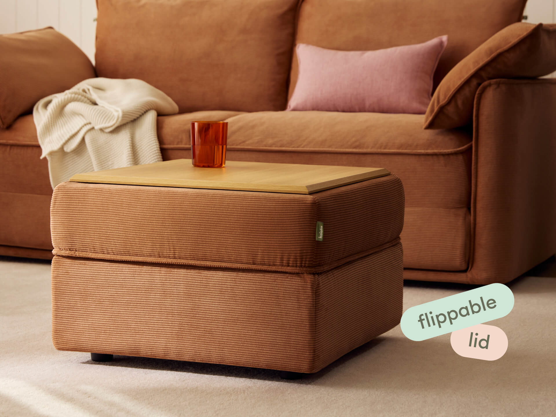 Koala Sofa Bed Ottoman in terracotta corduroy in living room with matching sofa and deep seats text overlay