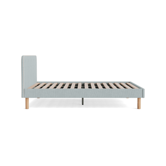Light grey upholstered bed frame with wooden slats and round wooden legs. Minimalist design, side view. Ideal for modern bedroom decor.