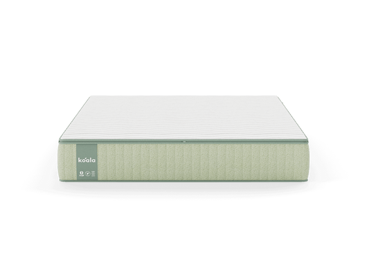 A light green mattress with a white top and stitched sides, featuring a visible label on the side.